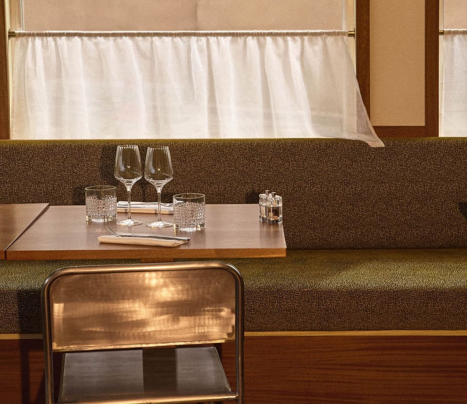 La banquette de la salle, table dressée dans la lumière du soir