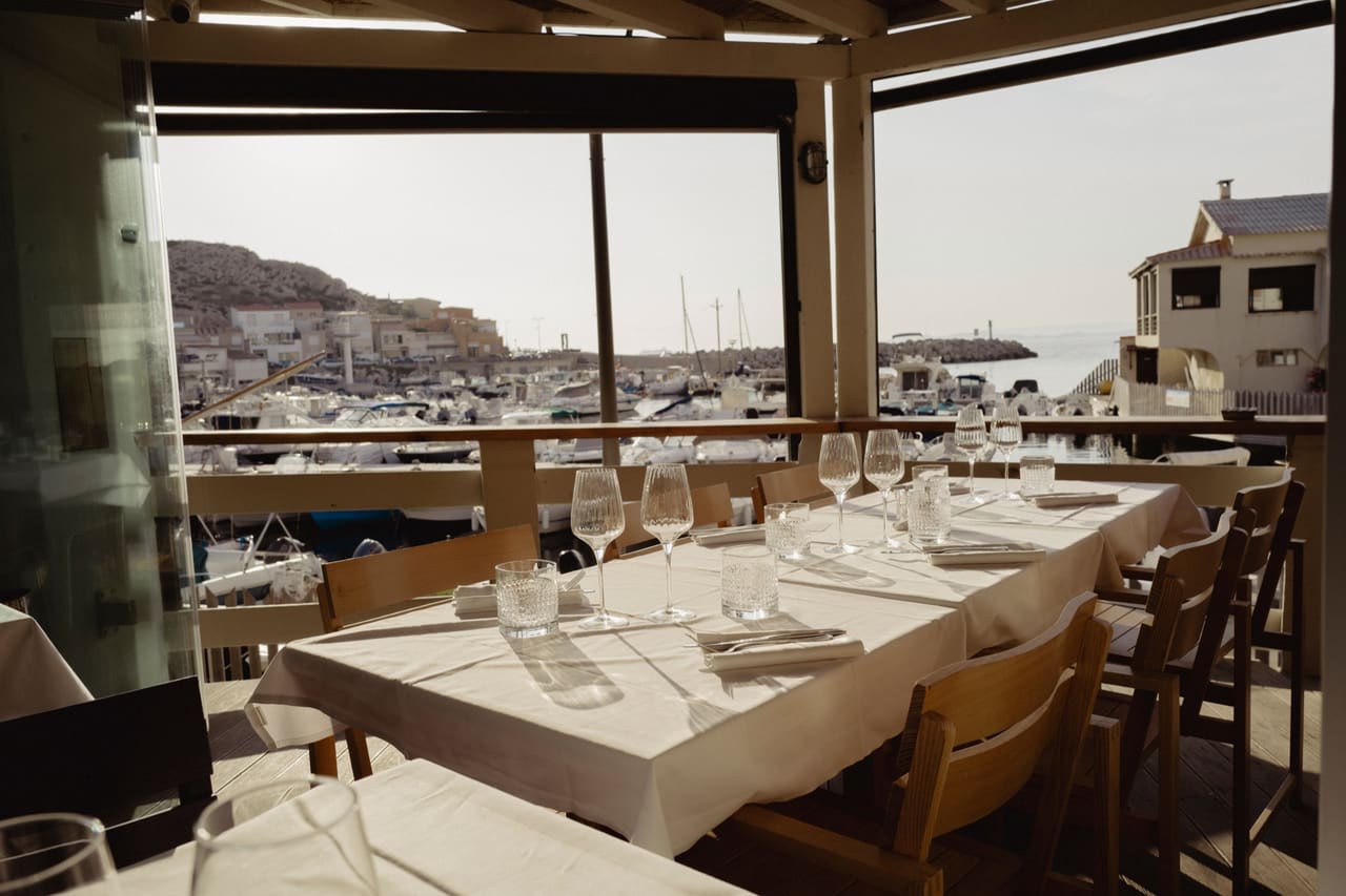Une grande tablée dressée en terrasse, face au port des Goudes