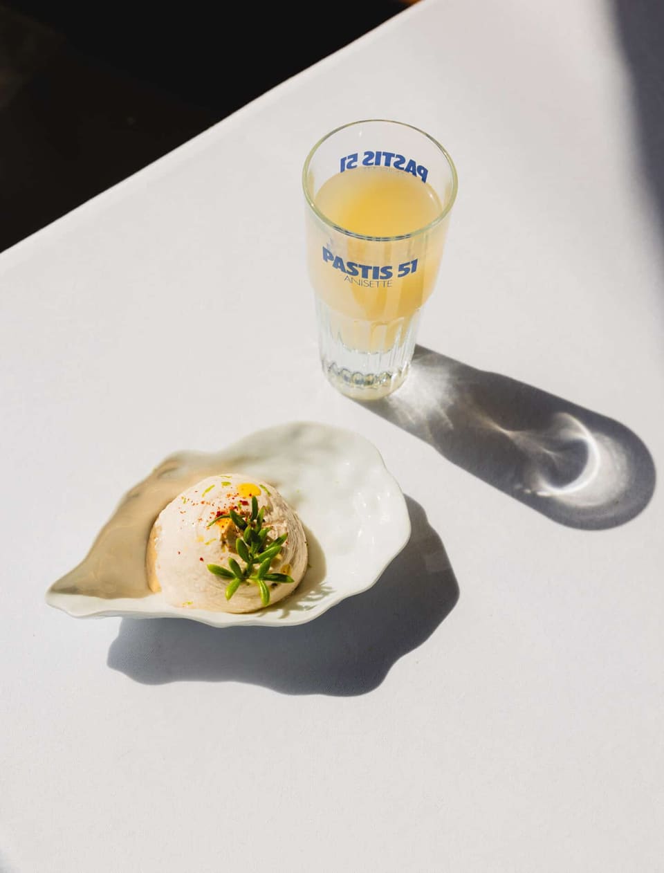 Un verre de pastis et la brandade servie en coquille, au soleil